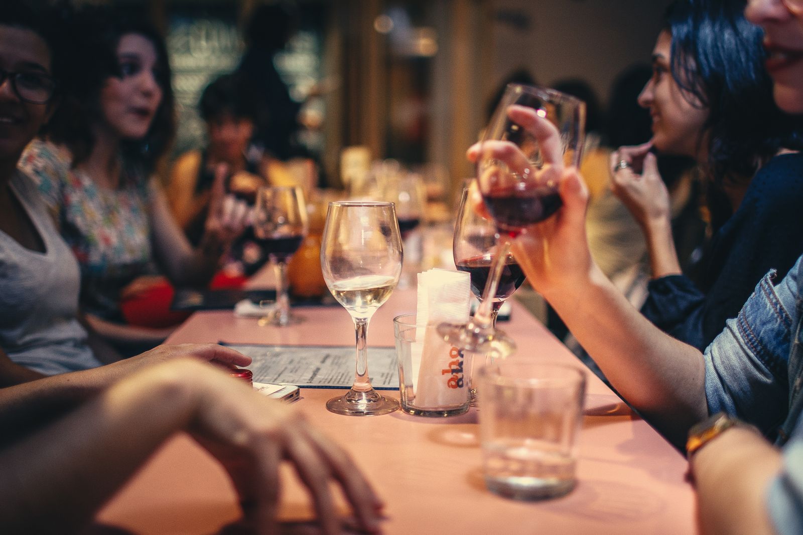 Friends toasting with wine over a shared dinner